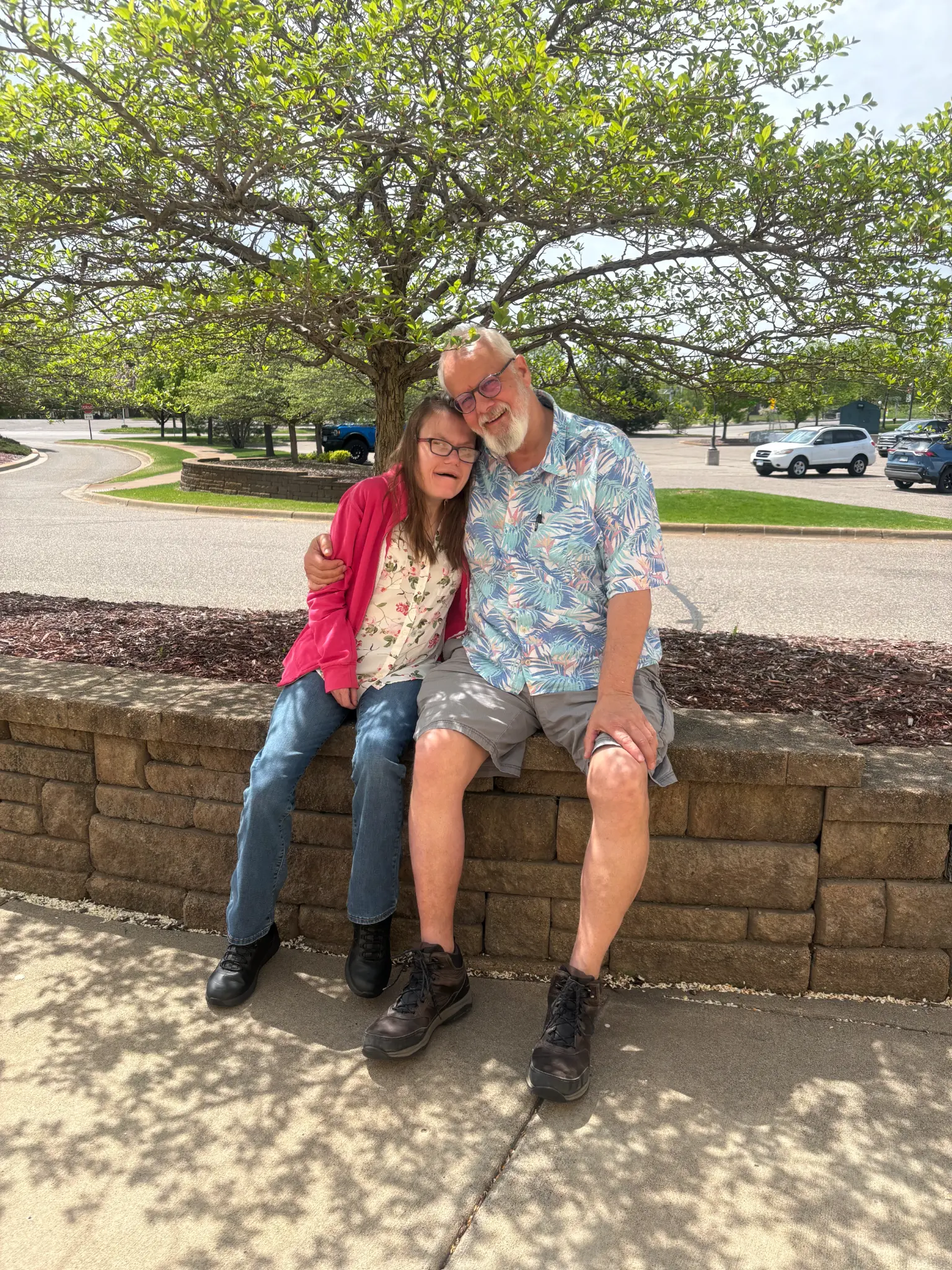 Lis and her father Henry sitting together under a tree